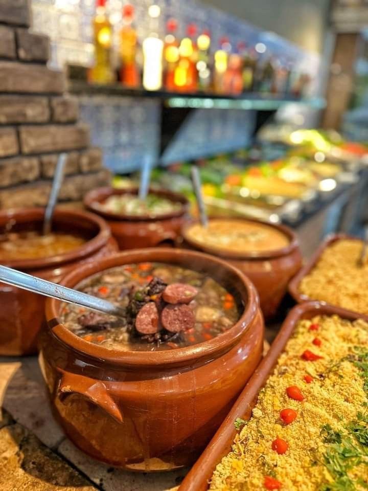 Panelas de barro com feijoada e acompanhamentos